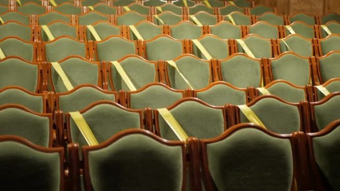 剧院或电影院大厅的空椅子。电影院大厅的座位用胶带覆盖，以保持社交距离。一个空的电影院大厅，椅子上覆盖