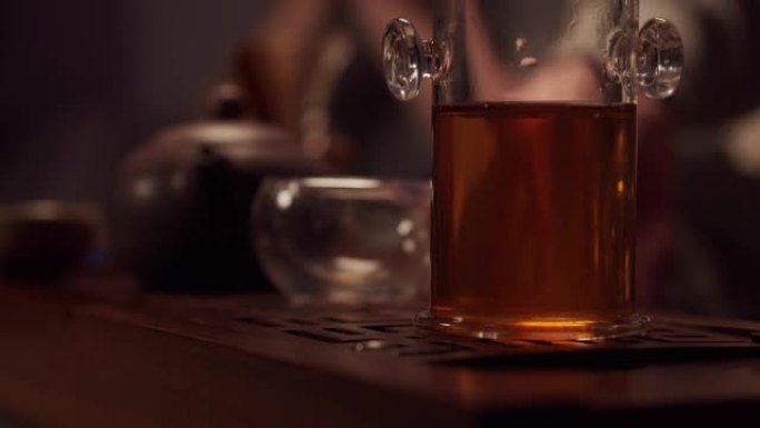 一个茶叶销售商准备在他的店里举行品茶仪式的特写镜头。在chaban上放置杯子，瓷茶壶和茶壶