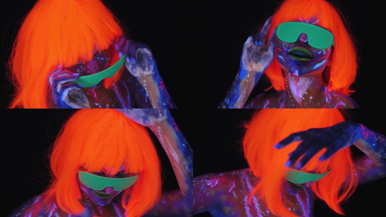 一个戴着橙色假发的脸上有紫外线图案的女孩在黑暗中跳舞
