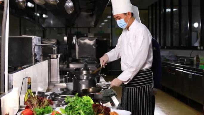 两位亚洲厨师的烹饪风格。他在明火锅里准备菜。他在餐厅厨房工作