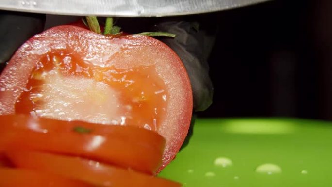 红色的西红柿是用大厨刀在木板上切的，宏观的，水滴的