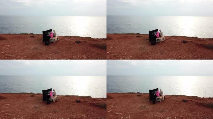 无人机视点-老人和孩子女孩在海滩上弹奏旧钢琴