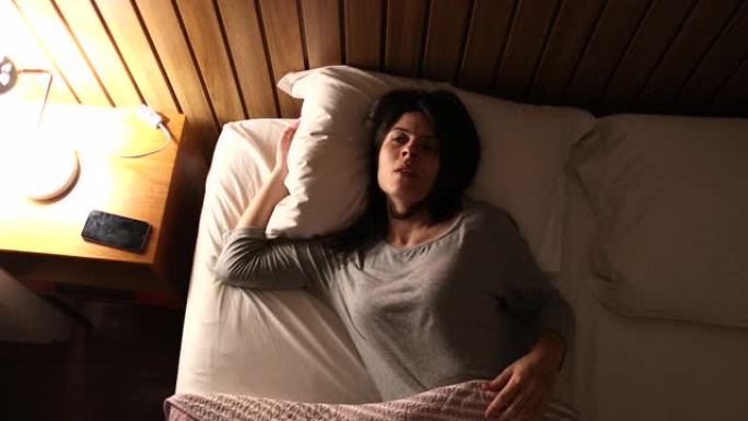 失眠的女人转向床头灯，侧身失眠