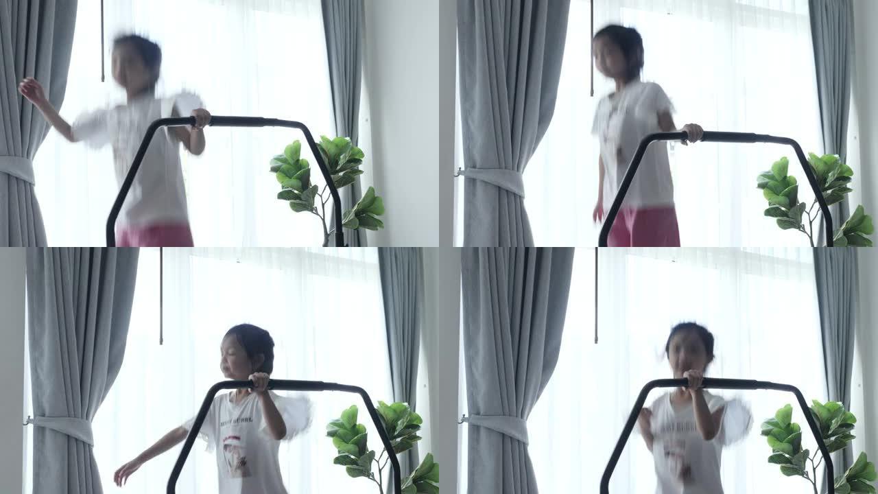 亚洲女孩在家里窗户附近的迷你蹦床上跳跃，运动概念。