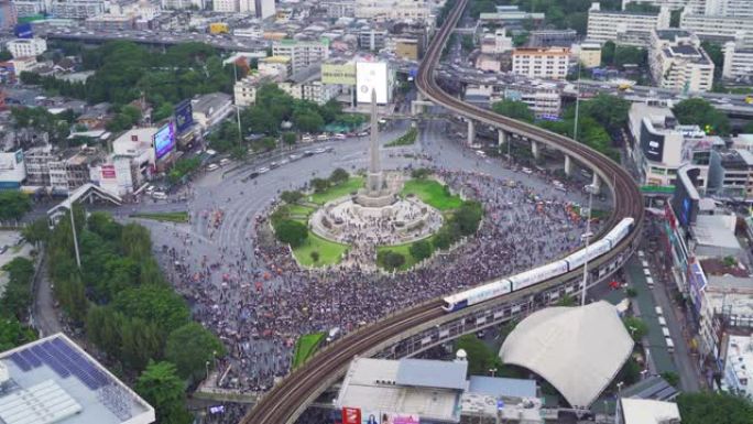 从空中俯瞰，快闪族抗议者在街道上集会反对政府，人群聚集在胜利纪念碑，在曼谷市，泰国的民主。