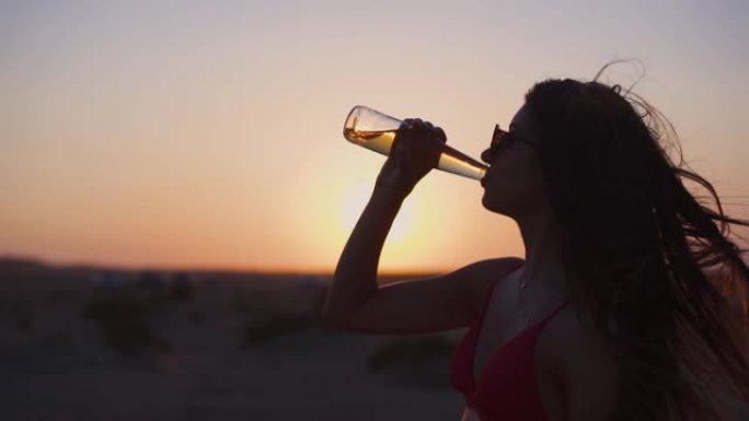 穿着比基尼的年轻西班牙裔妇女在暑假喝啤酒
