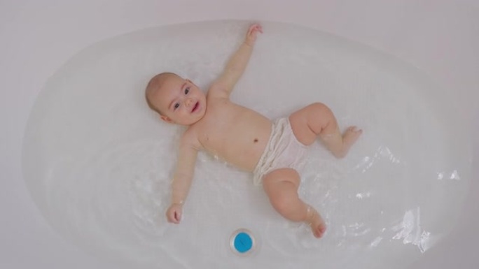 洗澡时有趣的新生儿游泳的俯视图