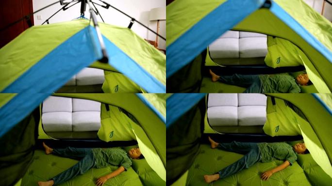 小男孩躺在家里的帐篷里