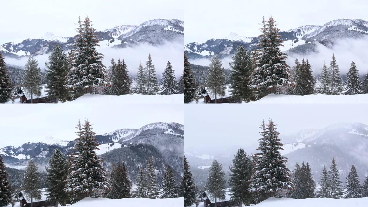 雪山有木屋的梦幻冬季景观。雪落在白雪覆盖的树上。