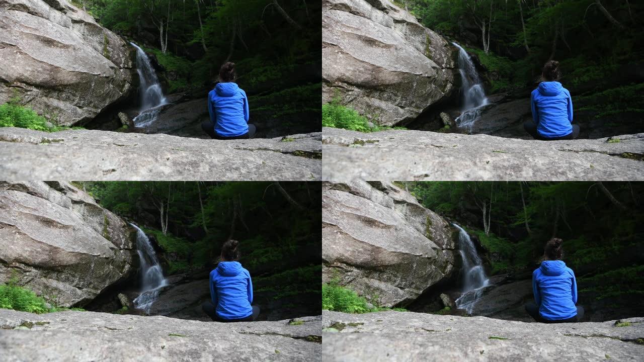 一个女人看着水顺流而下，放松下来。