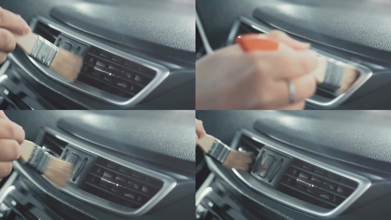 女性手清洁汽车内饰用特殊的灰尘刷，特写。汽车细节或高级洗车