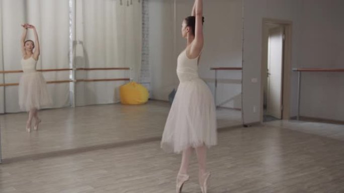 慢动作镜头。迷人的芭蕾舞女演员跳了一个美丽的跳跃，继续她的舞步和旋转
