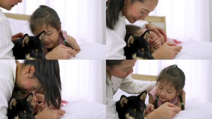 亚洲母女在家里快乐地玩狗。
