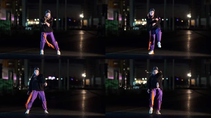 开朗的年轻女子在夜间在城市街道上以彩色背光跳舞嘻哈，自由泳或赃物