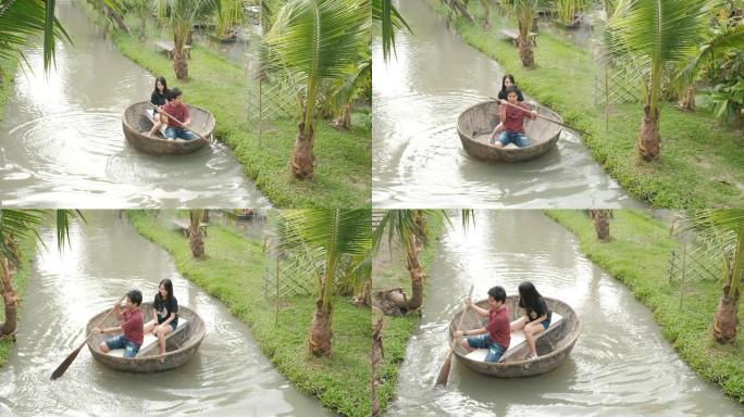 年轻的亚洲夫妇正在运河中划船。