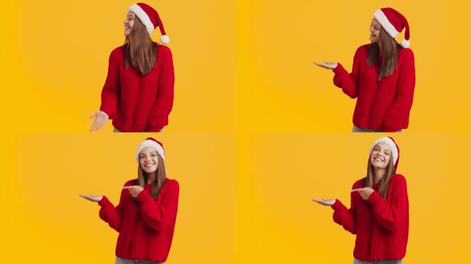 看这里。戴着圣诞老人帽子的千禧一代快乐女士在手上展示一些东西，享受圣诞节奇迹