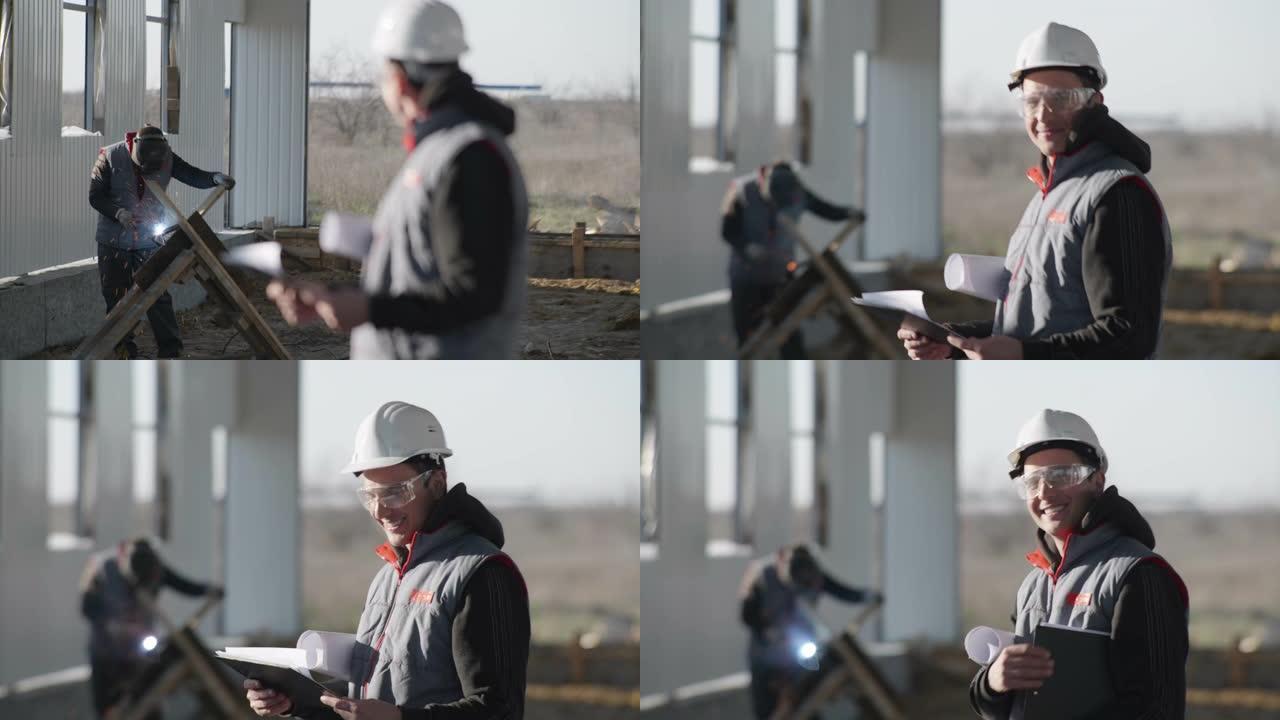 施工，在机库施工过程中，带焊接机和火花的背景下，手持图纸的男工程师在防护头盔中的肖像