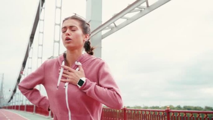 疲惫的女运动员在桥上呼吸急促地奔跑和停止
