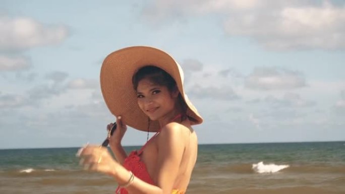 在海滩上散步的亚洲女人。美丽的亚洲女性在泰国海滩上快乐放松