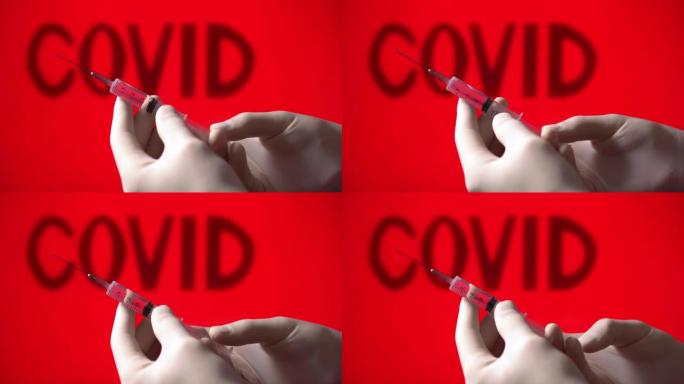 医用注射器与新型冠状病毒肺炎冠状病毒疫苗在红色背景与covid铭文。一名医生拿着注射器，注射来自冠状