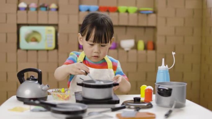 蹒跚学步的女孩假装玩食物准备