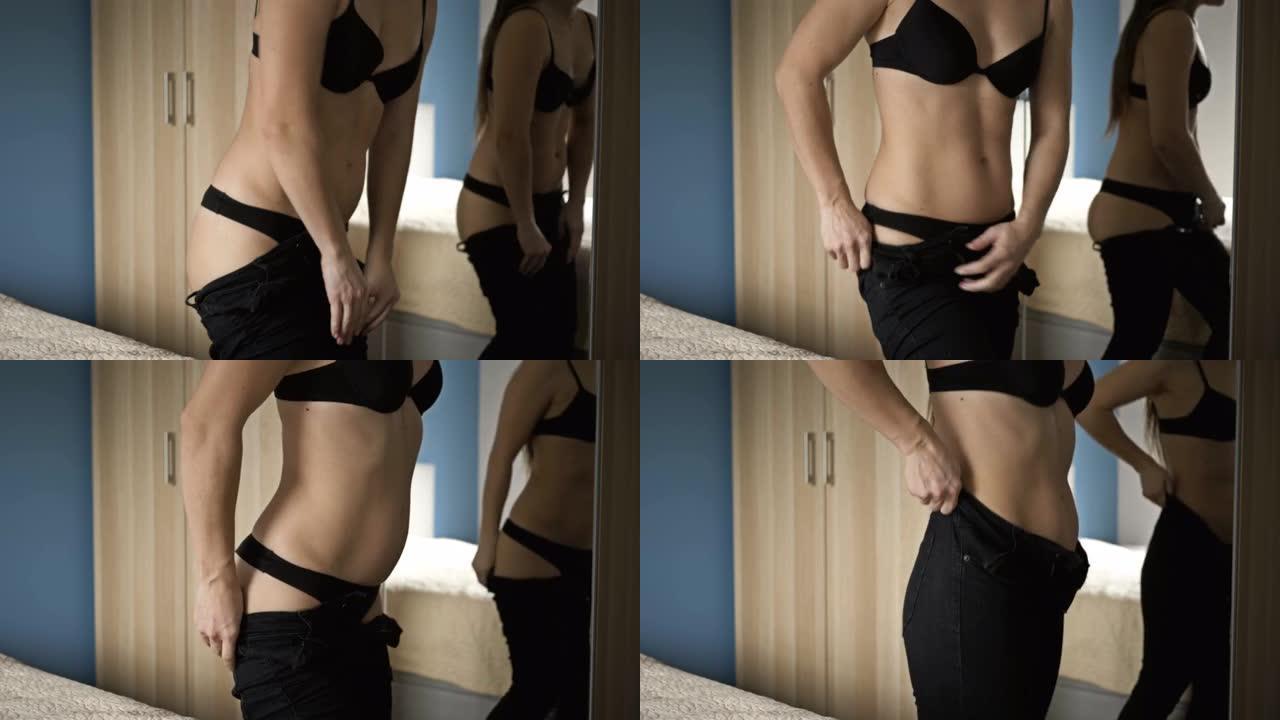 女人站在镜子前体重增加后挣扎着拉起紧身牛仔裤
