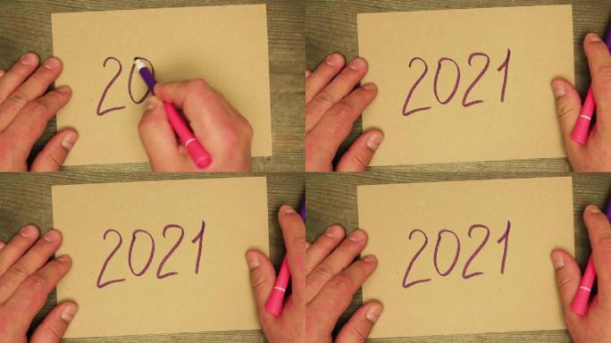 男性手写在纸板2021上的紫色毡尖笔。