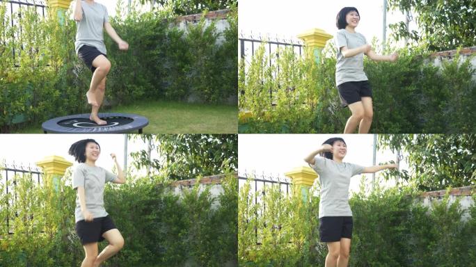 快乐的亚洲妇女在后院蹦床上跳跃