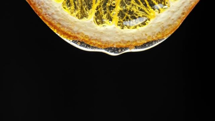 蜂蜜从新鲜的柠檬片上滴下来的宏观纹理镜头。新鲜、柑橘和流感补救概念。