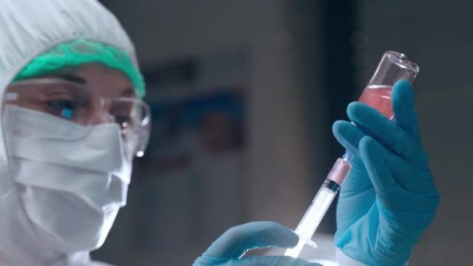 危险科学实验在研究实验室，生物物理学家在白色防护服用小瓶的红色溶液填充注射器并准备测试。集中的女性科