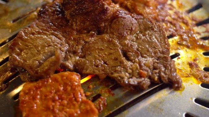 餐厅的韩国烧烤，在热板上烤一片肉的特写镜头。