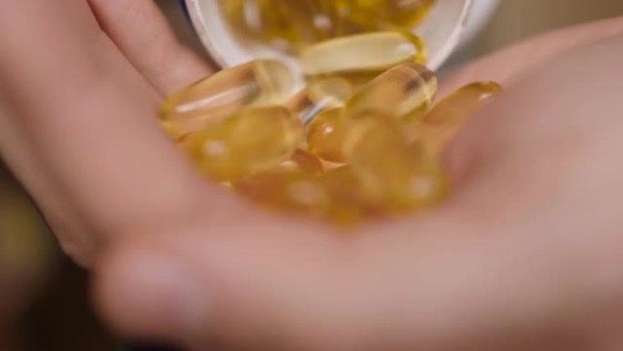 欧米茄3黄金鱼油胶囊。天然药物，运动，健康的生活方式，补充剂，饮食，营养，减肥，维生素d。男人倒鱼油