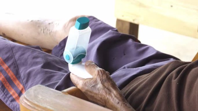亚洲男子手持哮喘吸入器