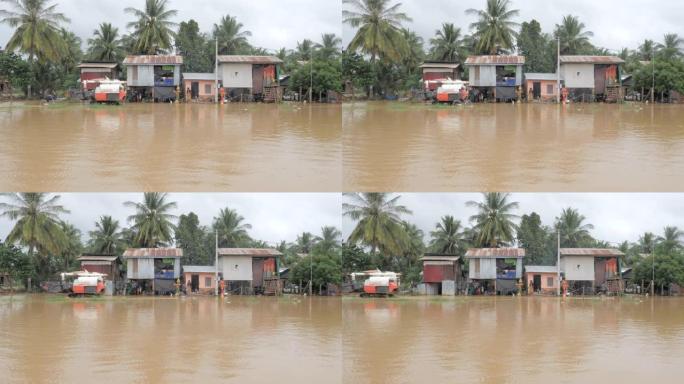 联合收割机在村民骑自行车穿过被水淹没的村庄时移动