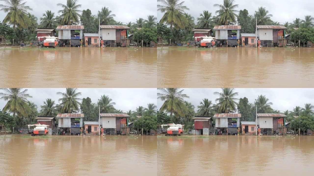 联合收割机在村民骑自行车穿过被水淹没的村庄时移动