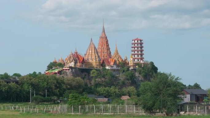 时光流逝的Wat tham sua或tiger cave temple，带有绿色的茉莉稻田，蓝天，阳