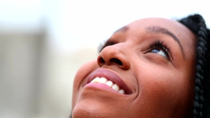 非洲女人仰望天空感受自由和幸福，黑人女孩特写脸