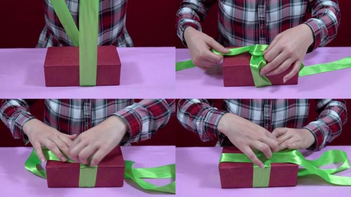 女人用红色包装纸包裹圣诞节，新年礼物，收紧绿色丝带蝴蝶结