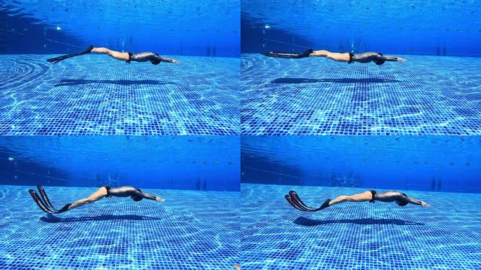 水下景观跟踪女人穿一件长袖比基尼剪裁潜水服做海豚踢鳍游泳动态呼吸暂停与双鳍在游泳池