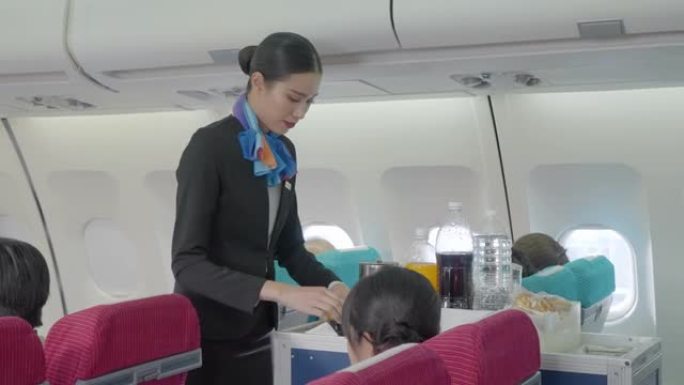 空姐在飞机上的航空公司工作人员在飞机上的客舱为经济舱的乘客提供食物和饮料。