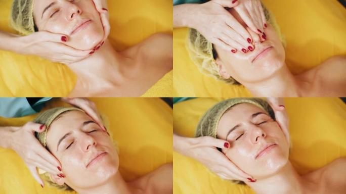 美容，面部按摩。特写。女人躺在沙发上，在美容诊所接受面部按摩，肌肉和面部皮肤淋巴引流。护肤，抗衰老程