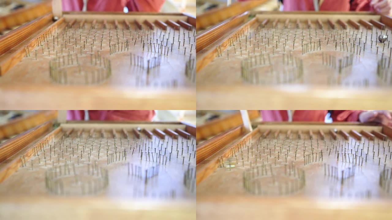 在木头做的弹珠台上特写。玻璃珠在弹珠台上滚落。一个孩子玩的游戏。主题在左边。