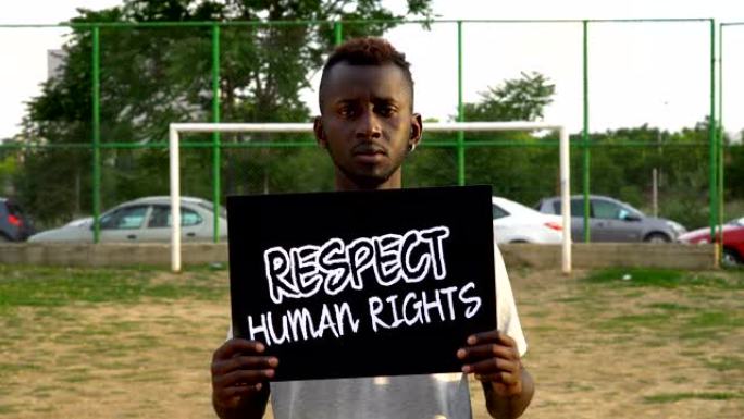 年轻的非洲抗议者拿着纸板 “尊重人权”