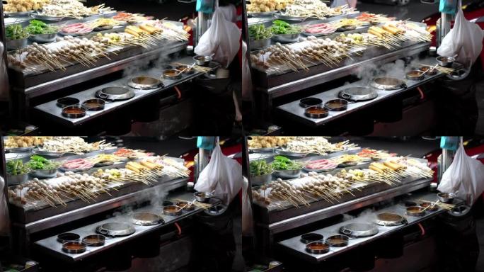 街头食品、什锦烧烤肉、鱼丸和带酱汁的竹签上的蔬菜。街头小吃卖在东南亚很受欢迎