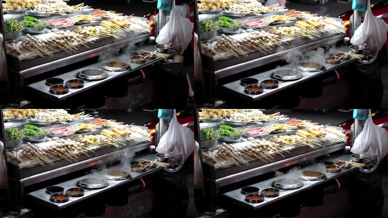 街头食品、什锦烧烤肉、鱼丸和带酱汁的竹签上的蔬菜。街头小吃卖在东南亚很受欢迎