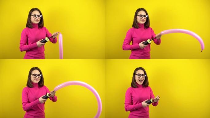 一名年轻女子用黄色背景上的泵给一个长长的粉红色气球充气。穿着粉色高领毛衣和眼镜的女孩。