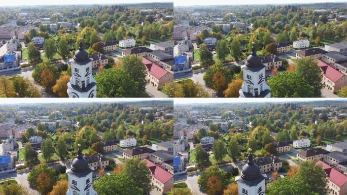 古老的Aluksne路德教会位于色彩缤纷的秋季公园，塔顶有金鸡雕像。拉脱维亚阿卢克斯内市。
