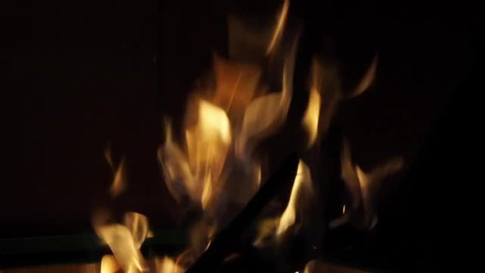 火焰上的黑色，美丽的火焰火焰在黑色的背景纹理。壁炉的慢动作移动。黄颜色温暖炉边。