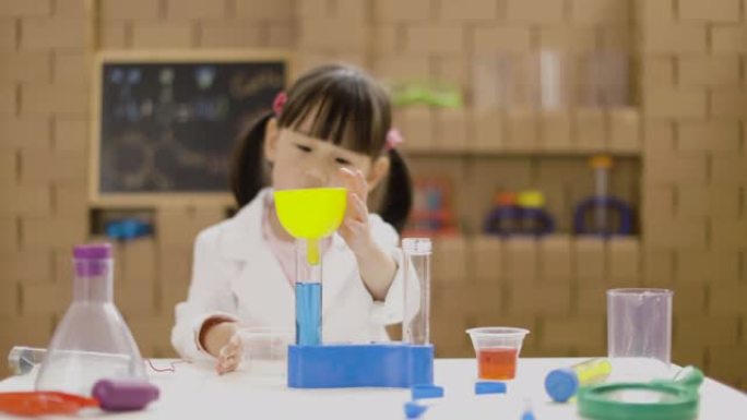 蹒跚学步的女孩玩能量棒液体导体科学实验