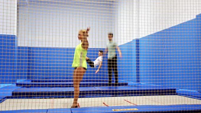 在现代健身中心锻炼期间，女性和男性在蹦床上跳跃和弹跳